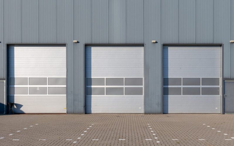 Row of grey industrial Units with roller shutter doors.